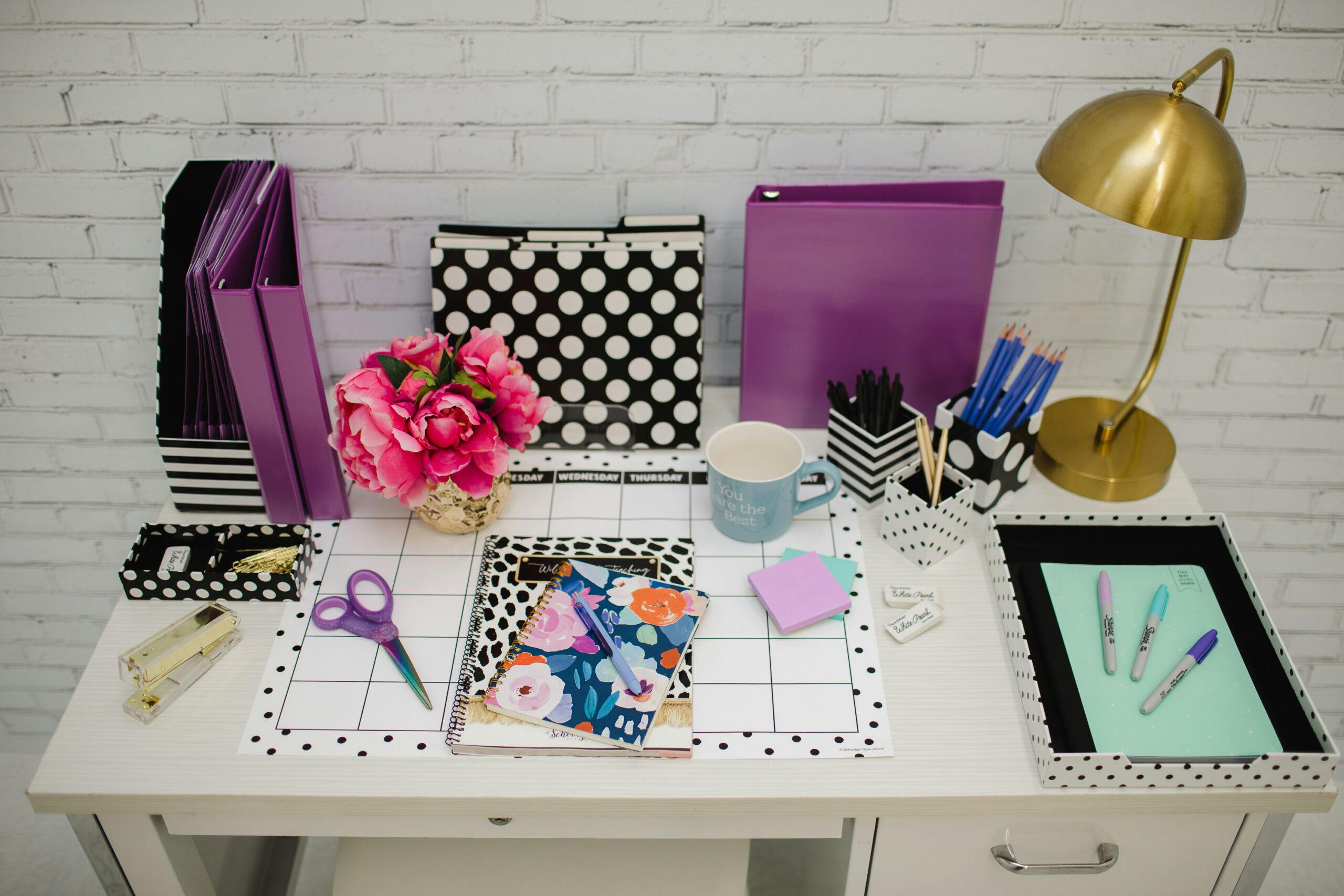 Image of a teacher desk styled with purples, black and white and gold
